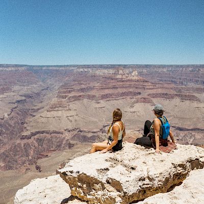 Hiking Friends sitting at Edge of Grand Canyon
